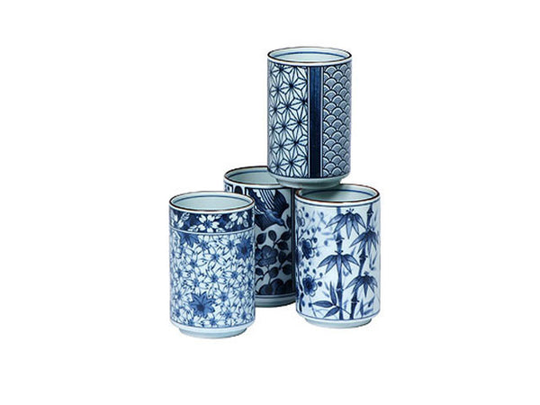 Four blue on white tea cups with various floral and plant designs